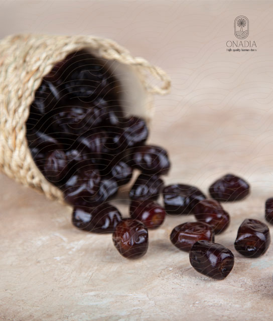 A wooden basket with mazafati dates falling out of it